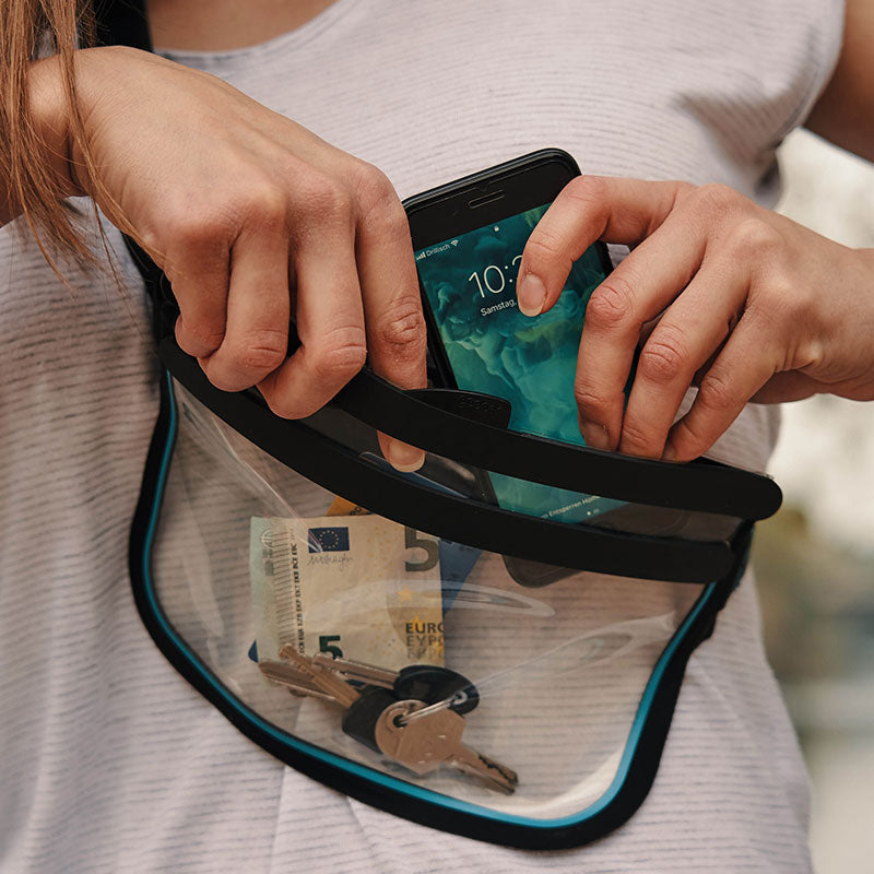Rangement d'un téléphone dans le sac Fidlock Hermetic Sling Bag porté en bandoulière